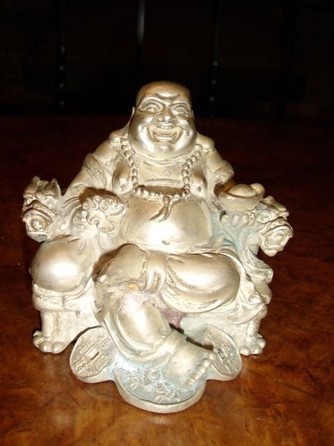 asian silver buddha sitting with broad smile